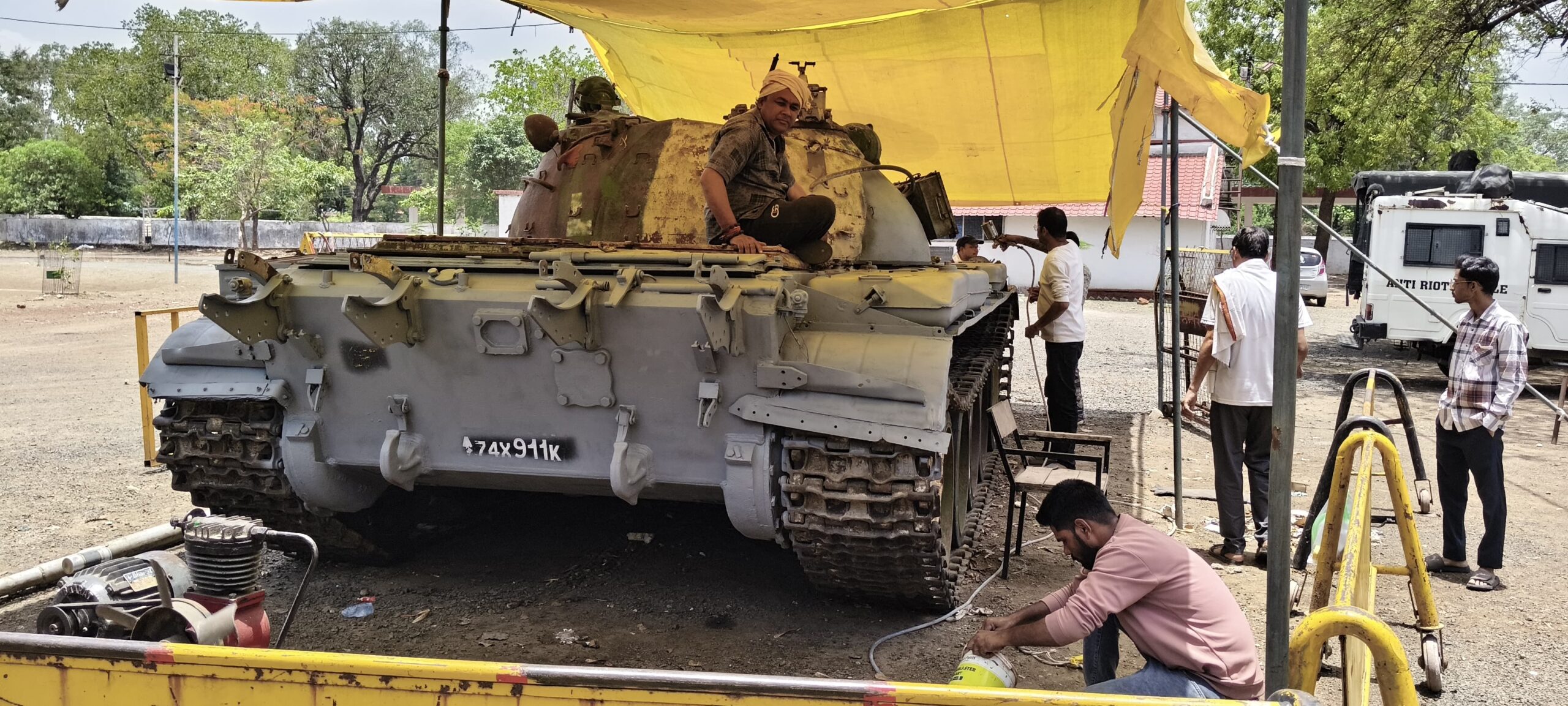 "स्थानीय कलाकार भारतीय सेना के T-55 टैंक को मूल रंगरूप में रंगते हुए"