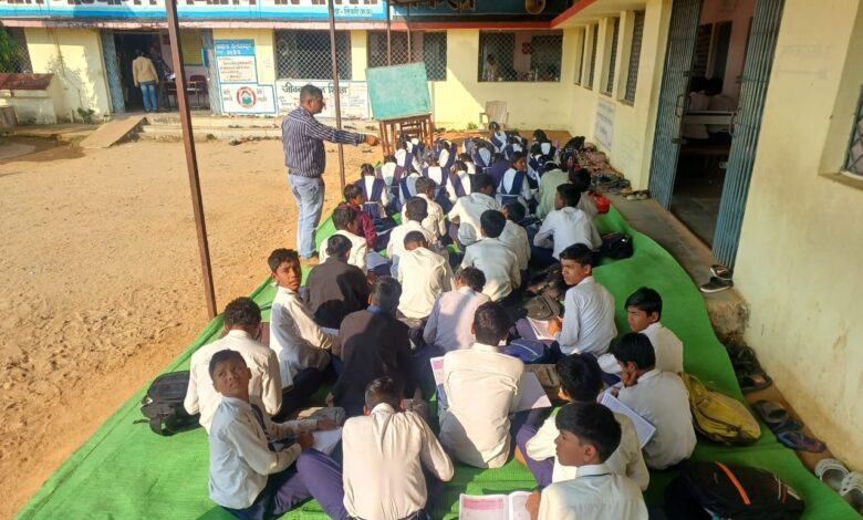 धारनाकला विद्यालय में छात्र बरामदे में दरी बिछाकर पढ़ाई करते हुए