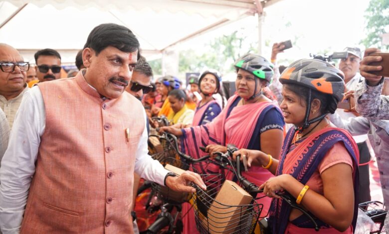 मुख्यमंत्री मोहन यादव महिला कर्मयोगी बहनों को ई-साइकिल वितरित करते हुए