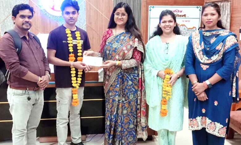 कलेक्टर नेहा मीना अंतरराष्ट्रीय निशानेबाज हेमंत वर्मन को 50 हजार रुपये की सहायता का चेक देते हुए