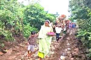 दुकली की खराब सड़क से कीचड़ में होकर गुजरती महिलाएं